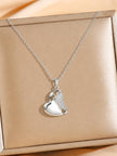 Silver heart pendant necklace with cubic zirconia wing detail displayed on a gold jewellery box
