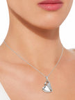 Silver heart pendant necklace worn on a model at collarbone length against a white top