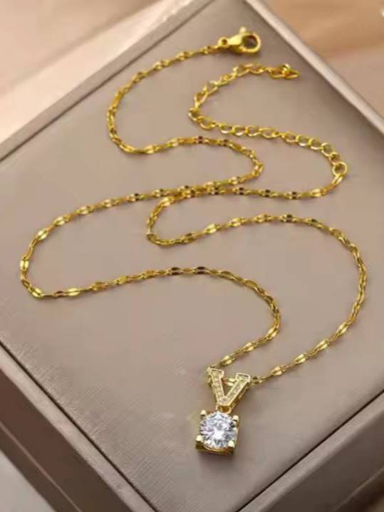 Full-length view of gold-tone oval-link chain with V pendant and lobster clasp in a jewellery box
