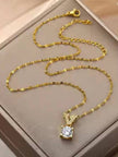 Full-length view of gold-tone oval-link chain with V pendant and lobster clasp in a jewellery box