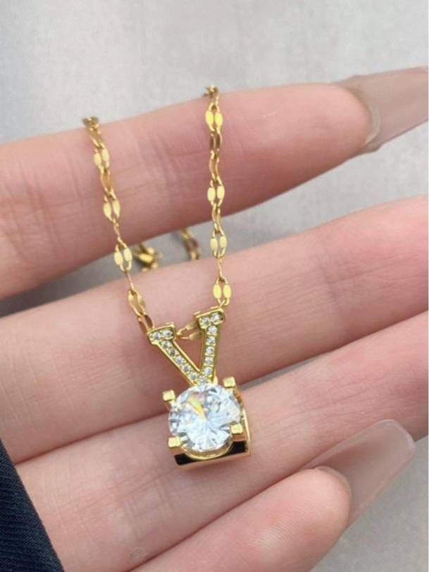 Gold V letter pendant necklace laid out in an S-curve showing full chain length in a box