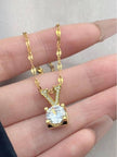 Gold V letter pendant necklace laid out in an S-curve showing full chain length in a box