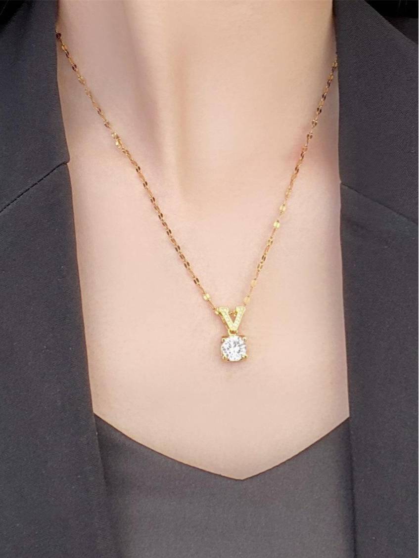Model holding V initial pendant necklace in palm showing chain detail and zirconia stone up close