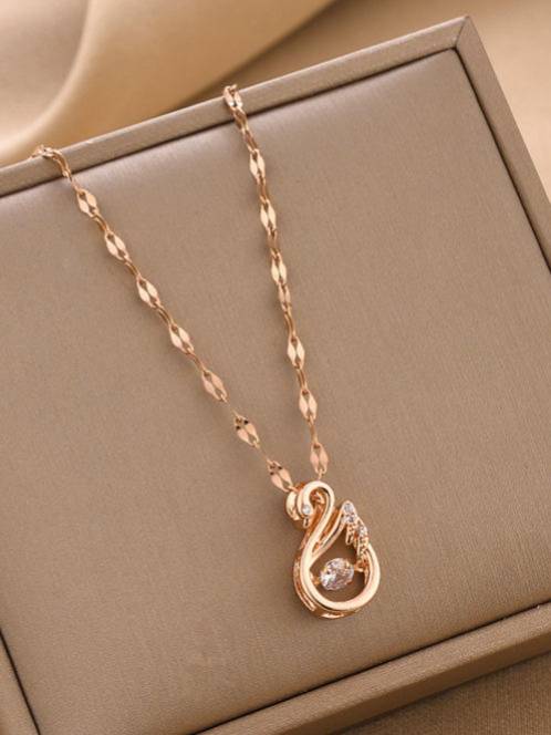 Rose gold swan pendant necklace displayed flat inside a beige jewellery box