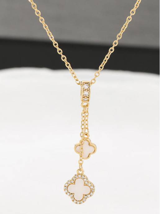Double clover necklace laid flat on white surface showing full chain length and two-charm drop pendant detail