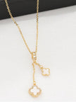 Close-up of double clover necklace on white surface showing CZ halo detail on the larger shell-inlay charm
