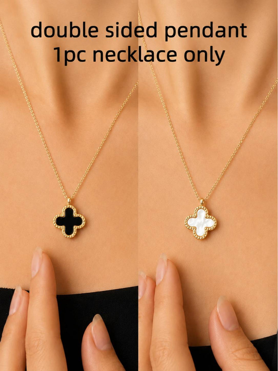 Double-sided clover necklace worn on neck showing black onyx side and white mother of pearl side