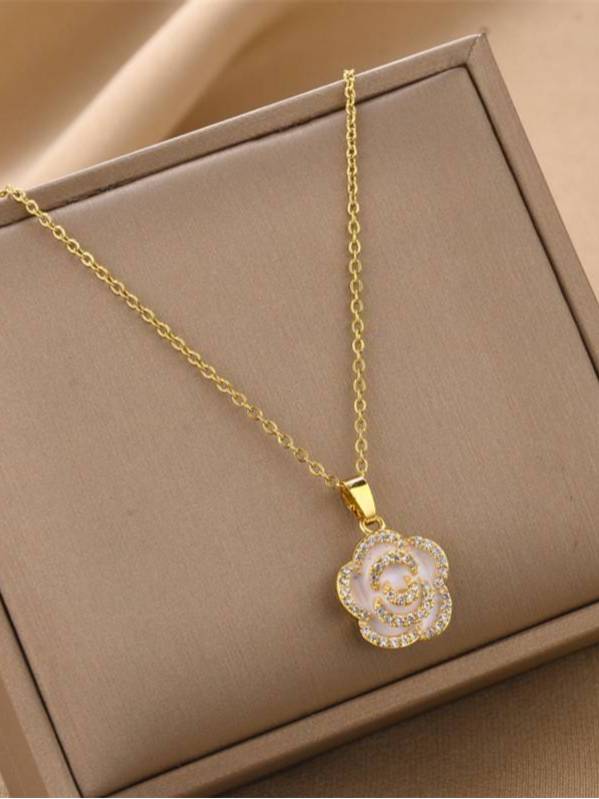 Gold-plated shell flower pendant necklace displayed flat inside a beige jewellery gift box