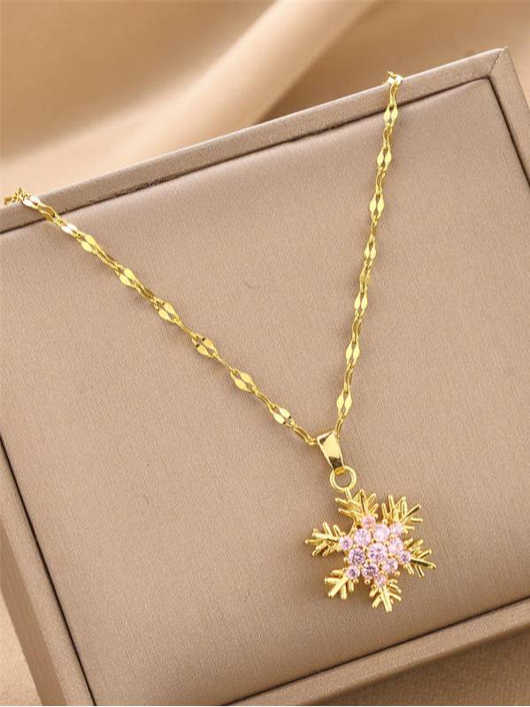 Gold-plated snowflake pendant necklace with pink cubic zirconia stones displayed in a beige jewellery box