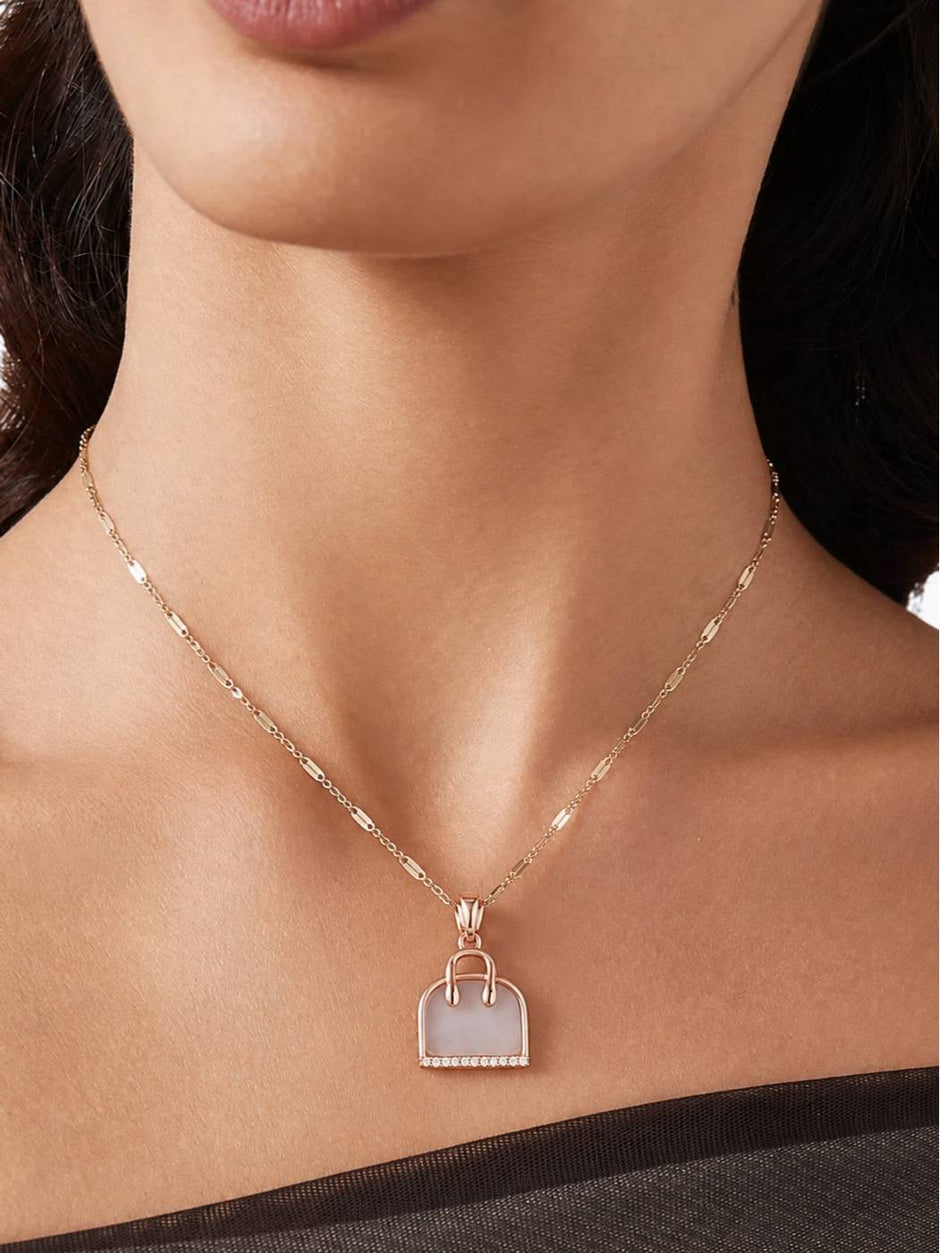 Model wearing rose gold handbag pendant necklace at collarbone length