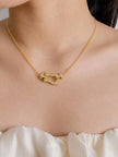Woman wearing gold-plated CZ horseshoe necklace at collarbone over a white ruffled top