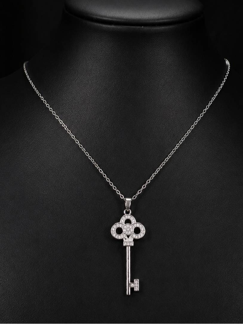 Silver-tone cubic zirconia key pendant necklace displayed on a black jewellery bust, front view