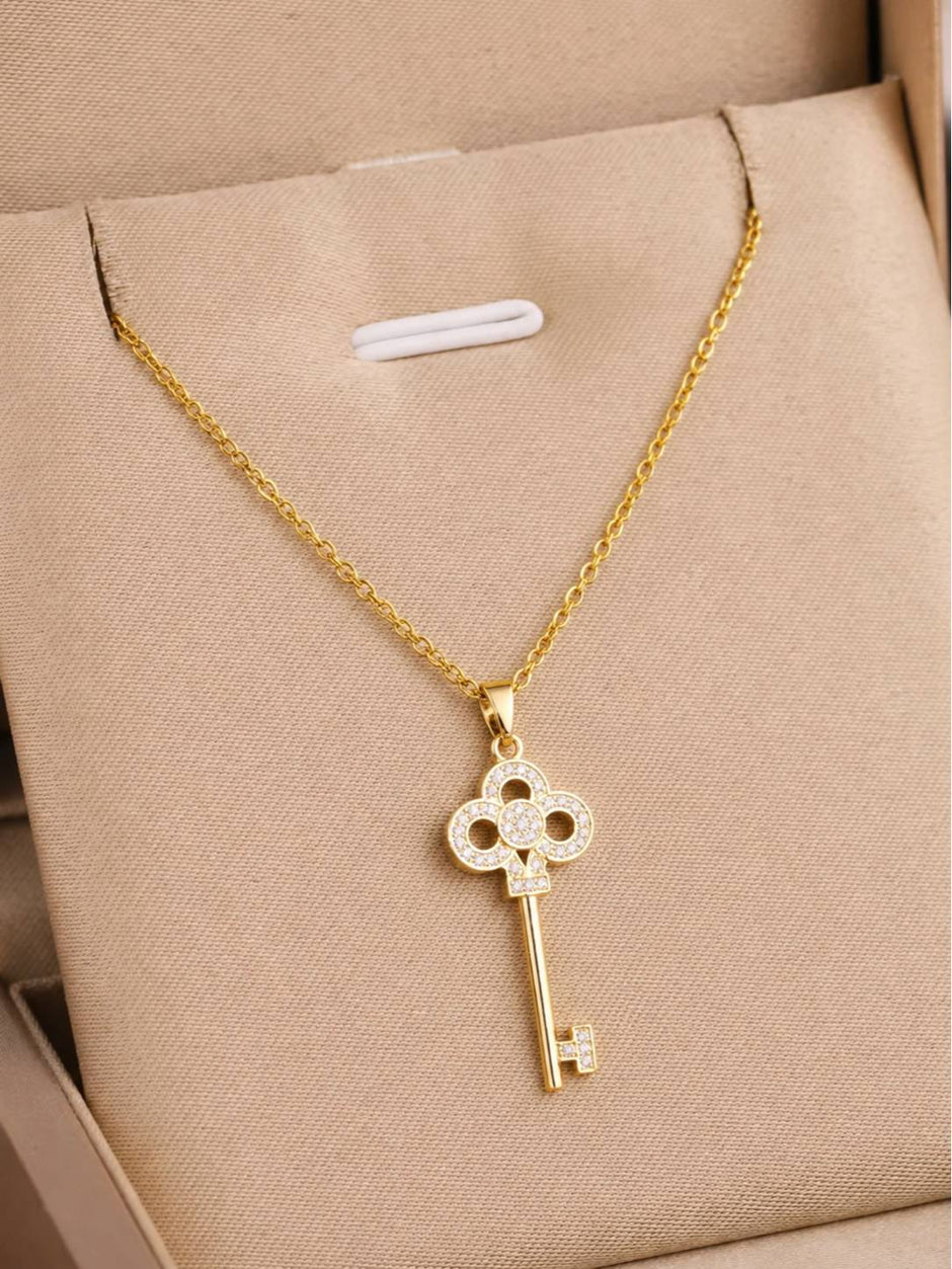 Gold-plated CZ key pendant necklace displayed inside a beige gift box