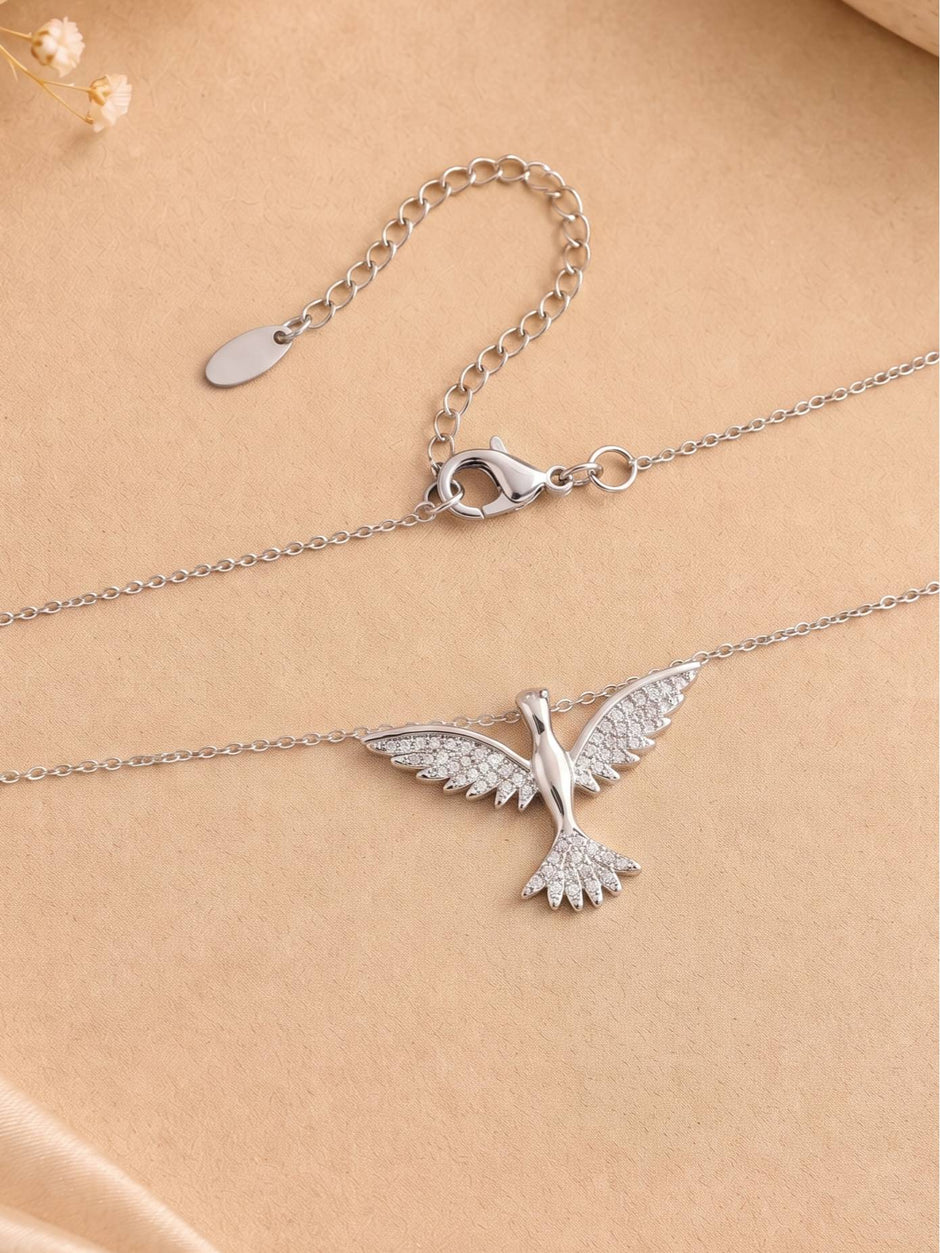 Reverse view of silver bird necklace showing lobster clasp and extender chain laid flat