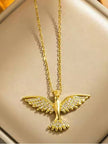 Gold-plated soaring bird pendant necklace with cubic zirconia wings displayed on a cream jewellery tray