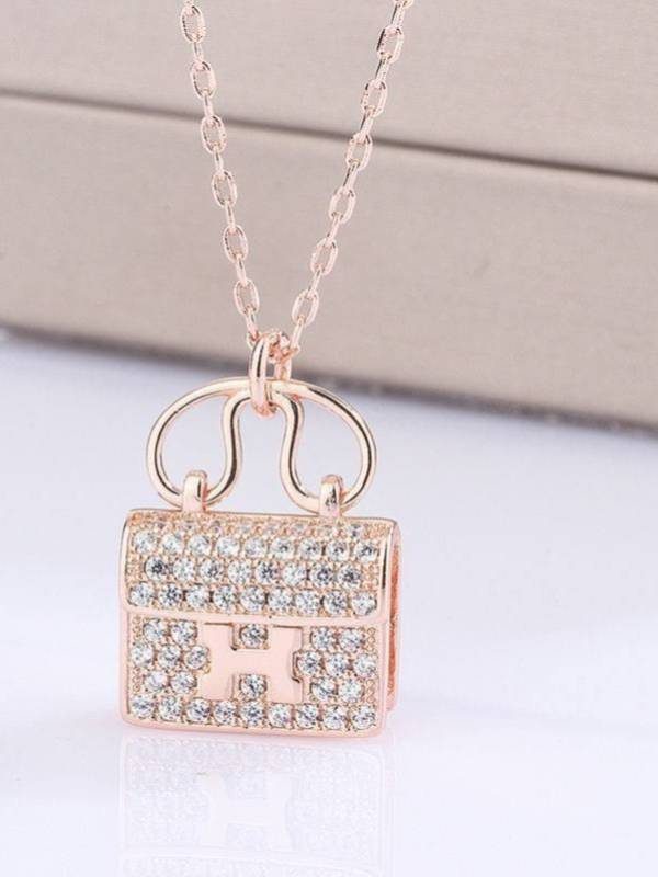 Close-up of three-dimensional rose gold handbag charm pendant fully encrusted with sparkling cubic zirconia stones