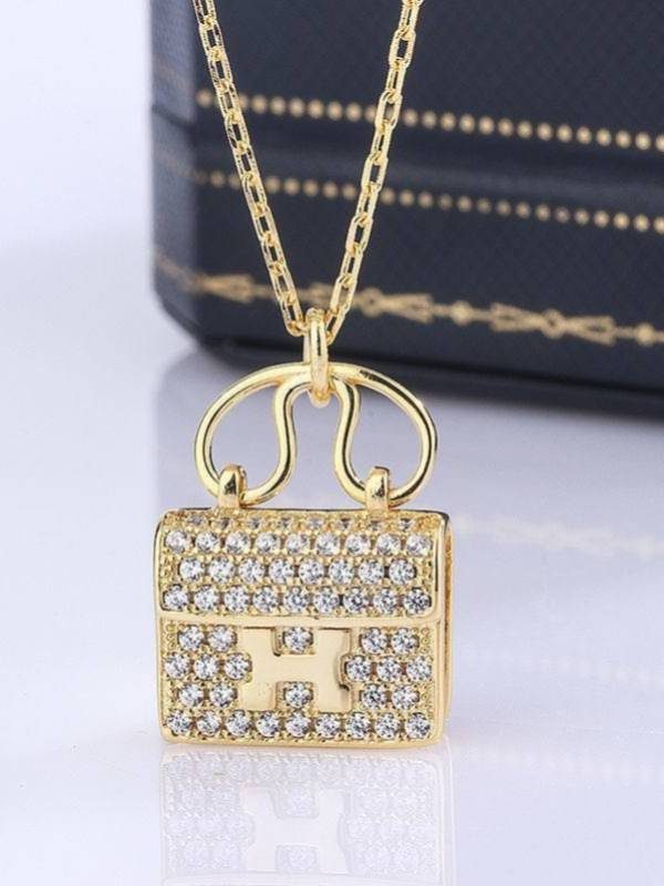 Close-up of gold-plated Constance-style bag pendant fully encrusted with round cubic zirconia stones