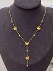 Gold-plated butterfly lariat necklace displayed on a dark jewellery bust, showing four butterfly charms and crystal rhinestones with a drop tail
