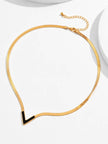 Gold-plated black enamel V necklace laid flat on a white surface showing full chain and lobster clasp