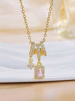 Gold-plated CZ pendant necklace with pink stone charm displayed on white decorative surface