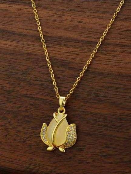 Gold-plated tulip pendant necklace laid flat on a dark wooden surface showing full chain