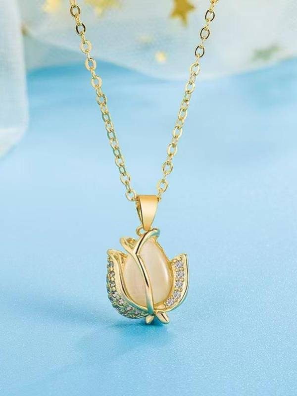 Close-up of tulip pendant with cat's-eye stone and cubic zirconia petals on a blue background
