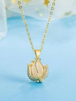 Close-up of tulip pendant with cat's-eye stone and cubic zirconia petals on a blue background