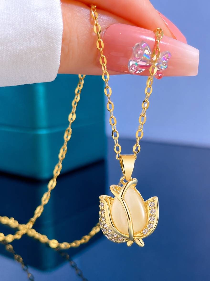 Hand holding gold tulip pendant necklace showing front detail and chain drape