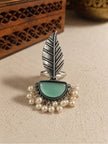 Front view of oxidised silver leaf ring with mint cat eye stone and ivory pearl drops on linen surface