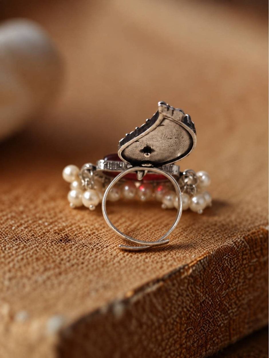 Back view of oxidised silver leaf ring showing open adjustable band and reverse of red stone setting