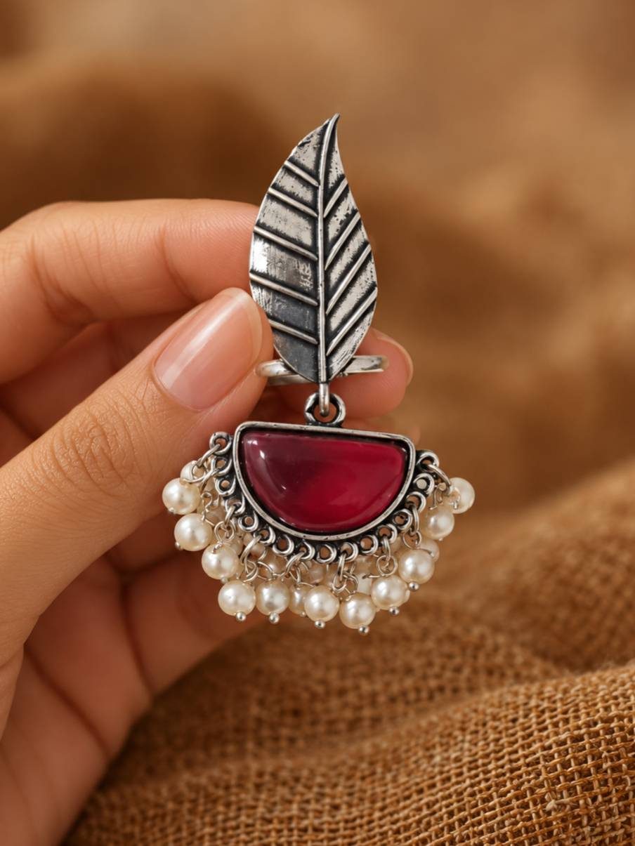 Hand holding oxidised silver leaf ring showing engraved leaf motif and cascading faux pearl fringe