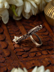Side profile of oxidised silver Mohi ring showing adjustable open band and pearl cluster against carved wooden background