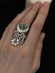 Oxidised silver Mohi Devanagari ring worn on middle finger showing full design with green stone and pearl drops