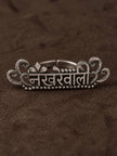 Oxidised silver Nakhrewaali ring laid flat on dark brown surface showing Devanagari inscription and filigree scrollwork