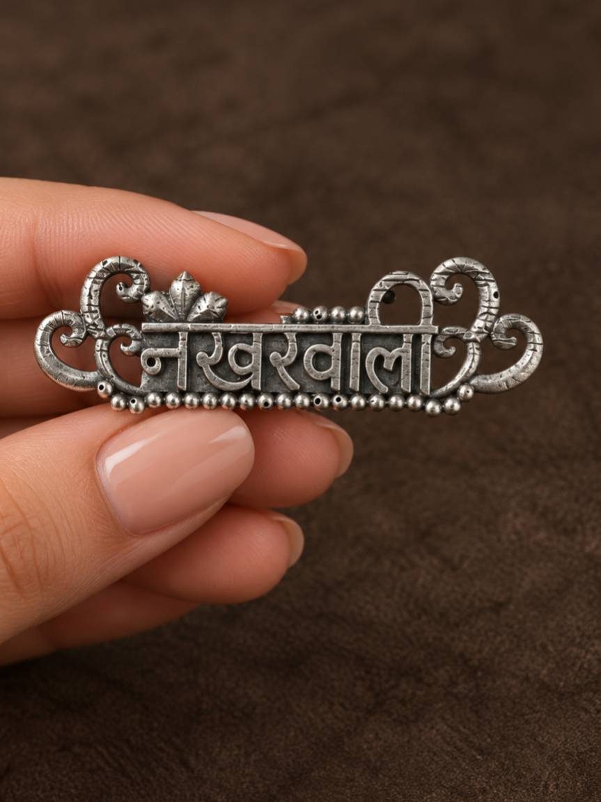 Close-up of Nakhrewaali oxidised silver ring held between fingers showing beaded border and detailed filigree frame