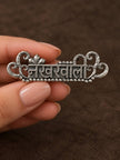 Close-up of Nakhrewaali oxidised silver ring held between fingers showing beaded border and detailed filigree frame