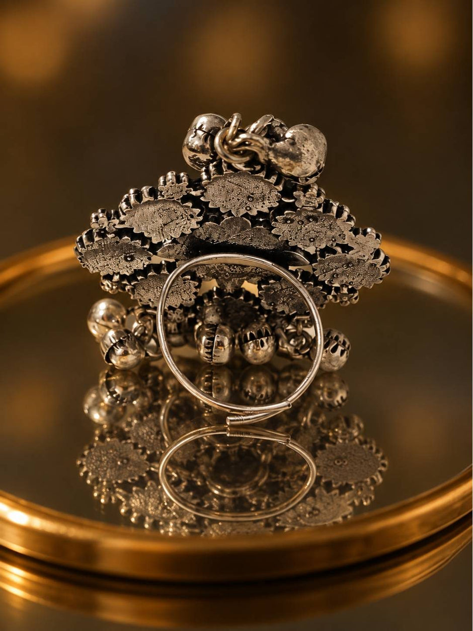 Back view of oxidised silver floral ring showing adjustable wire shank and ghungroo bells