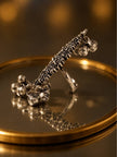 Side profile of oxidised silver ring with braided top band and cluster of ghungroo bells