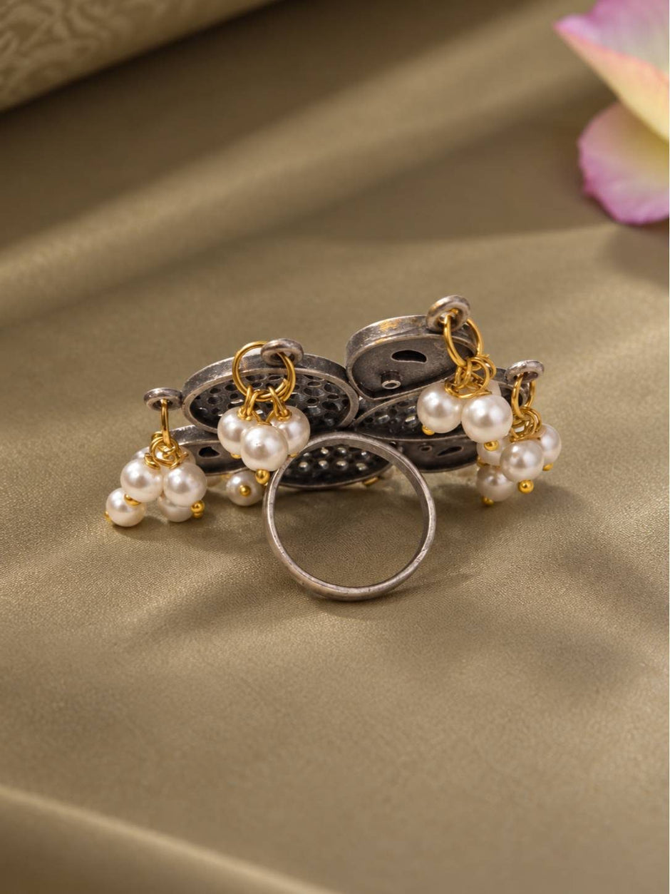Back view of oxidised silver floral ring showing jali dome underside, open adjustable band and pearl drop links