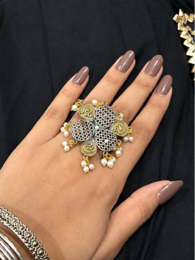 Oxidised silver dual-tone floral cocktail ring worn on a woman's finger against a black fabric background