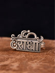 Front view of oxidised silver Radha name plate ring with Om crown and scroll detailing on stone surface