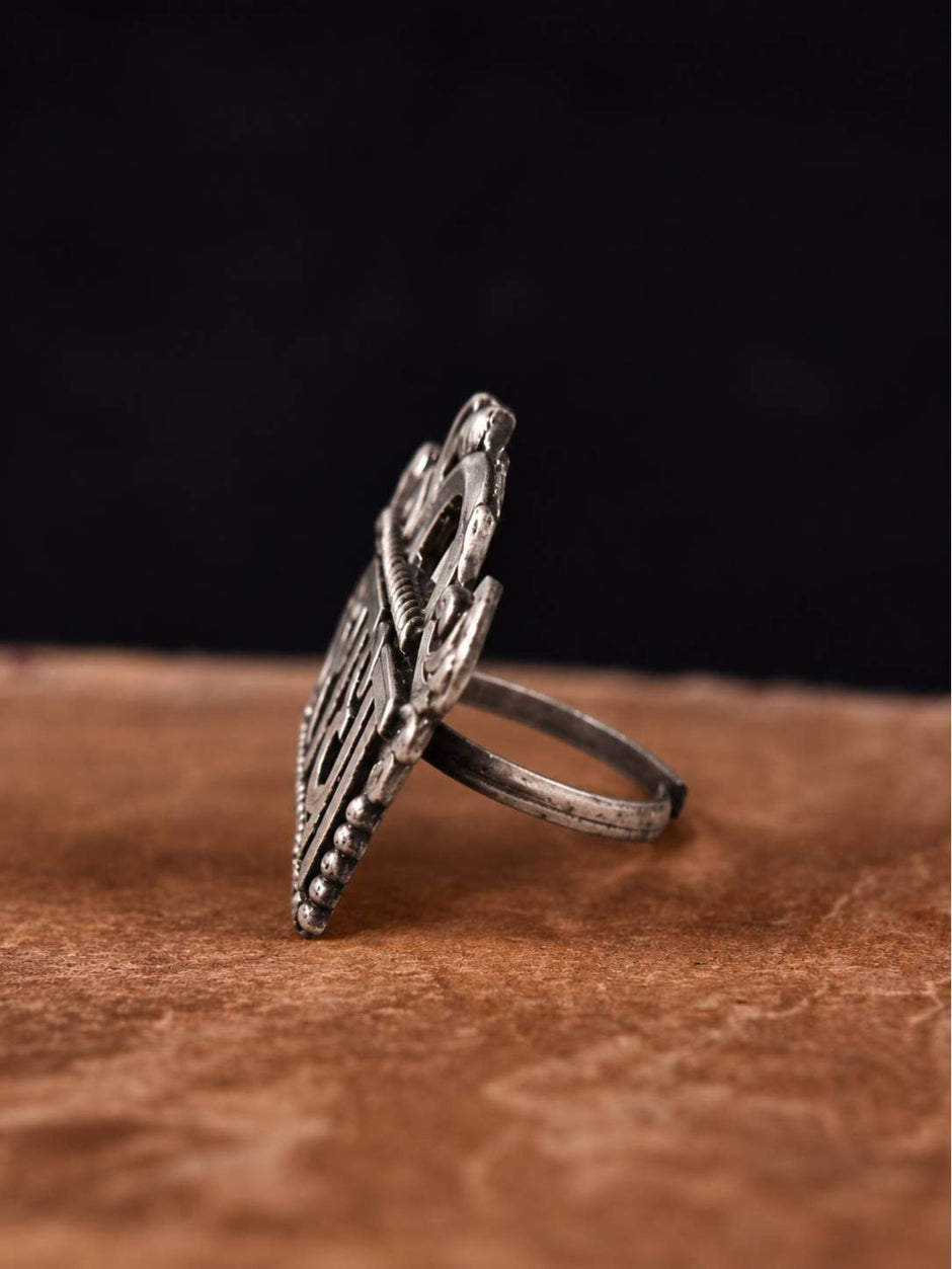 Side profile of oxidised silver Radha ring showing depth of carved Devanagari lettering and slim band