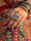 Oxidised silver Radha name plate ring worn on hand with mehndi, styled with colourful mirror-work ethnic outfit