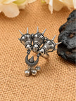 Front view of oxidised silver triple horse head ring with spike crowns and ghungroo bell drops on burlap