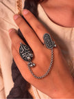 Oxidised silver dual finger chain ring worn on index and middle finger against a draped fabric background
