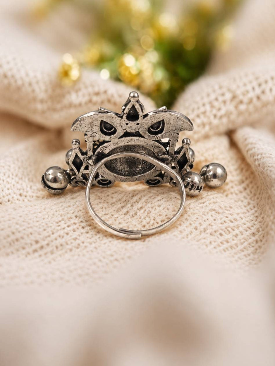 Back view of oxidised silver ring showing adjustable open-band and hollow dome construction on cream fabric