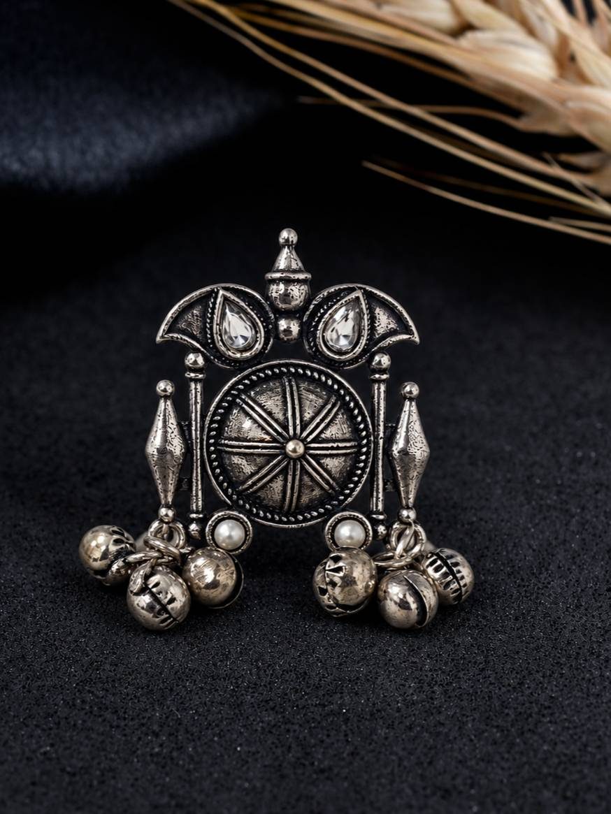 Front view of oxidised silver cocktail ring with sunburst disc, crescent motifs, crystal teardrops and dangling ghungroo bells