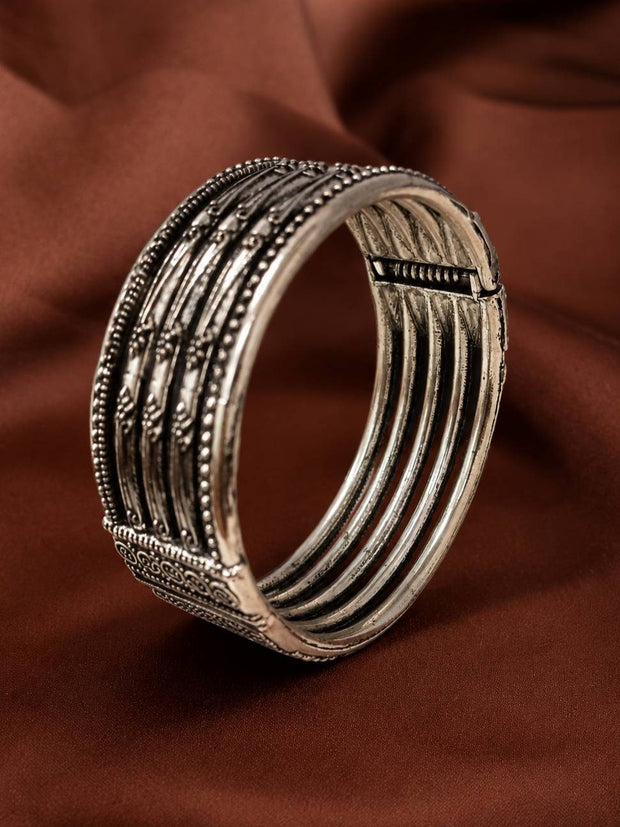 Side profile of oxidised silver cuff kada revealing spring-flex open back and diagonal engraved band detailing