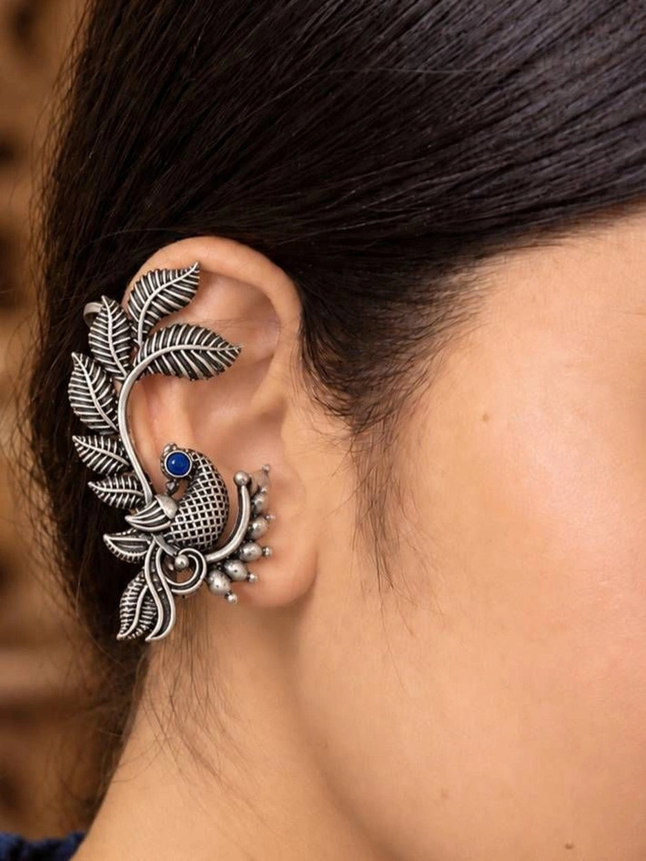 Oxidised silver peacock ear cuff earring worn on woman's ear showing full cartilage wrap fit