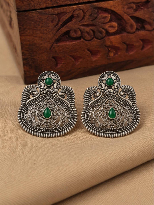 Front view of both oxidised silver filigree chandbali earrings laid flat on a cream fabric surface